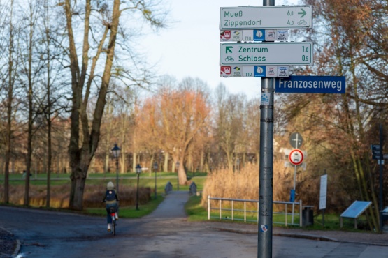 Anfang des Franzosenwegs im Schweriner Schlossgarten mit Radfahrerin 2024