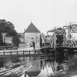 Schwarzweiß Foto von 1905: Im Vordergrund die Warnow mit Klappbrücke im Hintergrund das Petritor