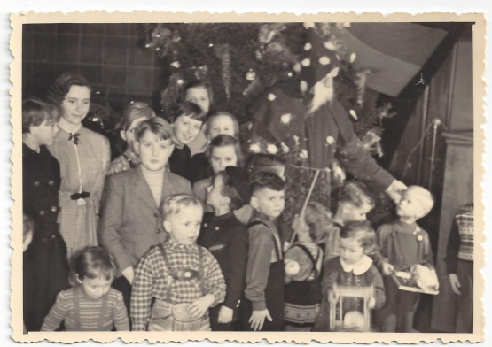 Schwarzweiß Foto mit Kindern, im Hintergrund Weihnachtsbaum und Weihnachtsmann