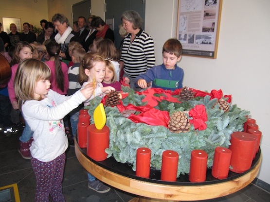 Kinder aus dem "Lankower Spielhaus" schmücken einen vom Diakonischen Werk Mecklenburg-Vorpommern e.V. übergebenen Adventskranz im Sozialministerium in Schwerin. Fm Mecklenburg