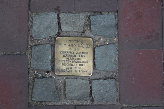 In einen Fußweg eingelassener, quadratischer &quot;Pflasterstein&quot; aus Messing mit dem Namen und Lebensdaten Willy Kaeckers, eingefasst von 8 gleichgroßen Granit-Steinen