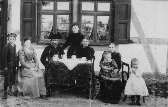 Schwarz-weiß Foto mit einer Gruppe Menschen vor einem Haus